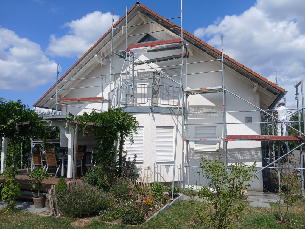Fassadenrenovierung: Einfamilienhaus mit Gerüst und frischem Fassadenanstrich