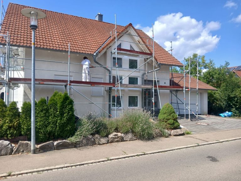 Maler bei der Arbeit an der Fassade eines Wohnhauses