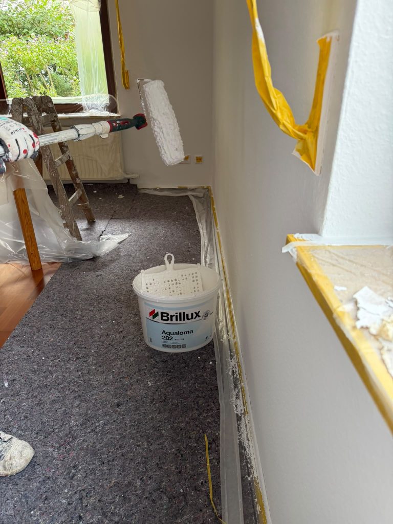 Wände werden mit der Rolle gestrichen, Fensterbank sauber abgeklebt